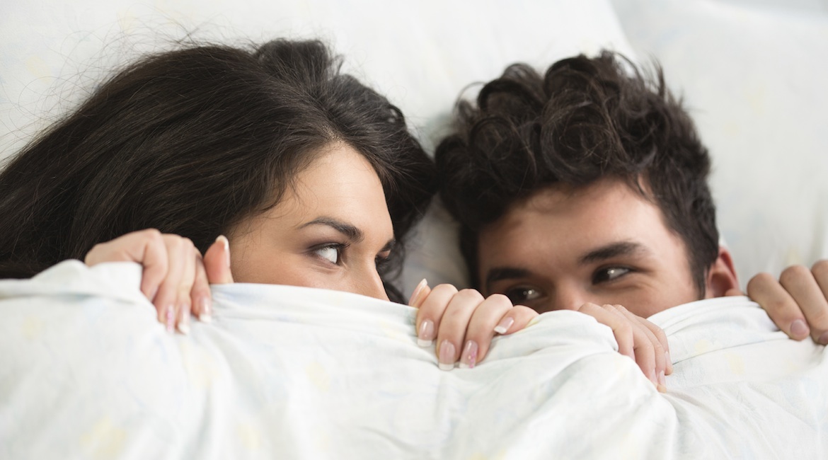 Young couple under duvet